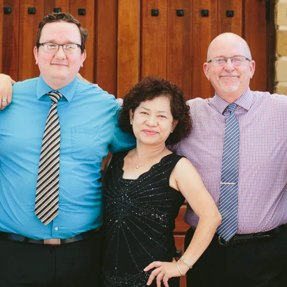 Five restaurant team members pose together outside wooden doors, with two chefs wearing black Freda’s uniforms.